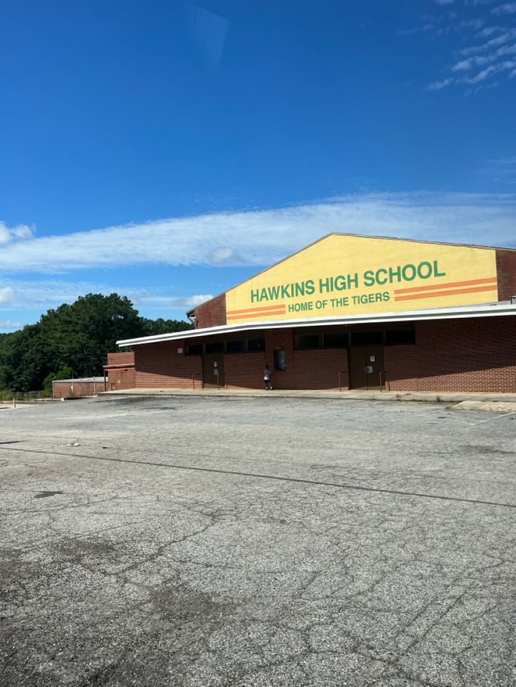 an empty parking lot in front of a building with a sign that says hawking high school on it