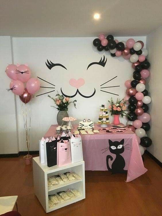 a cat themed birthday party with pink, black and white balloons