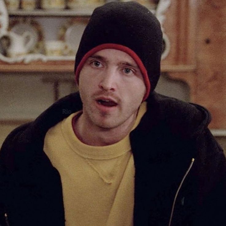 a young man wearing a beanie and looking surprised at something in front of him