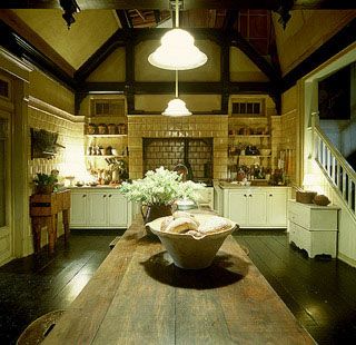 a large wooden table sitting inside of a kitchen next to a stair leading up to the second floor