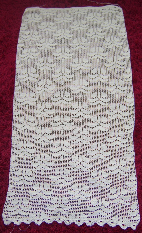 a white crocheted table runner on red carpet