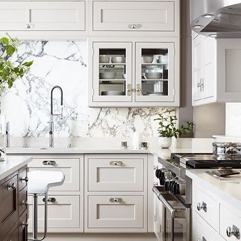 a kitchen with marble counter tops and white cabinets