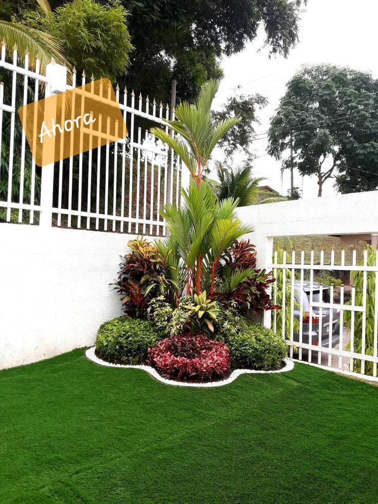 a white fence and some plants in the grass