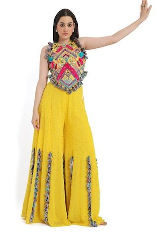 Yellow and multi color sleeveless back tie-up choli with all over bohemian tribe vibe embroidery and tassel embellishments. Paired with a mukaish dot embroidered sharara with tassel detailing. - Aza Fashions Yellow Bohemian Blouse For Diwali, Bohemian Yellow Blouse For Diwali, Multicolor Sleeveless Dress For Eid, Bohemian Fitted Sharara With Gota Work, Bohemian Sleeveless Sharara For Diwali, Bohemian Palazzo Set With Motifs For Festivals, Bohemian Yellow Blouse Piece For Festivals, Fitted Embellished Multicolor Traditional Wear, Bohemian Sleeveless Sets For Festival