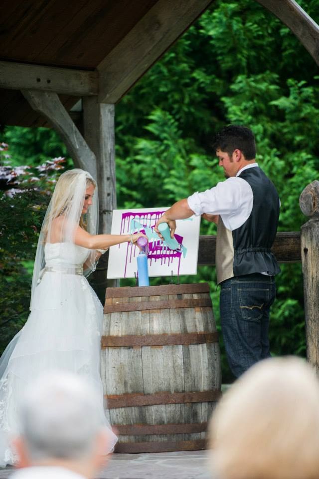 the bride and groom are getting married in front of an oak barrel at their outdoor ceremony