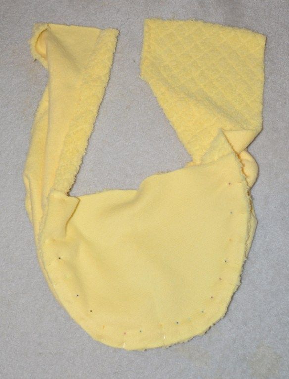 a piece of yellow cloth with holes in it on a white surface next to a pair of scissors