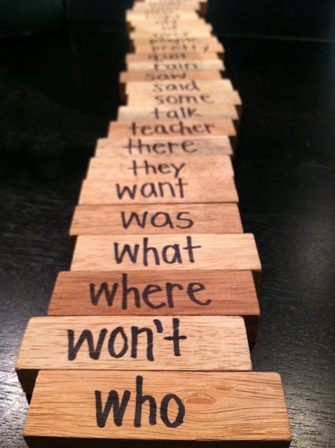 wooden blocks with words written on them that are lined up in the shape of a long row