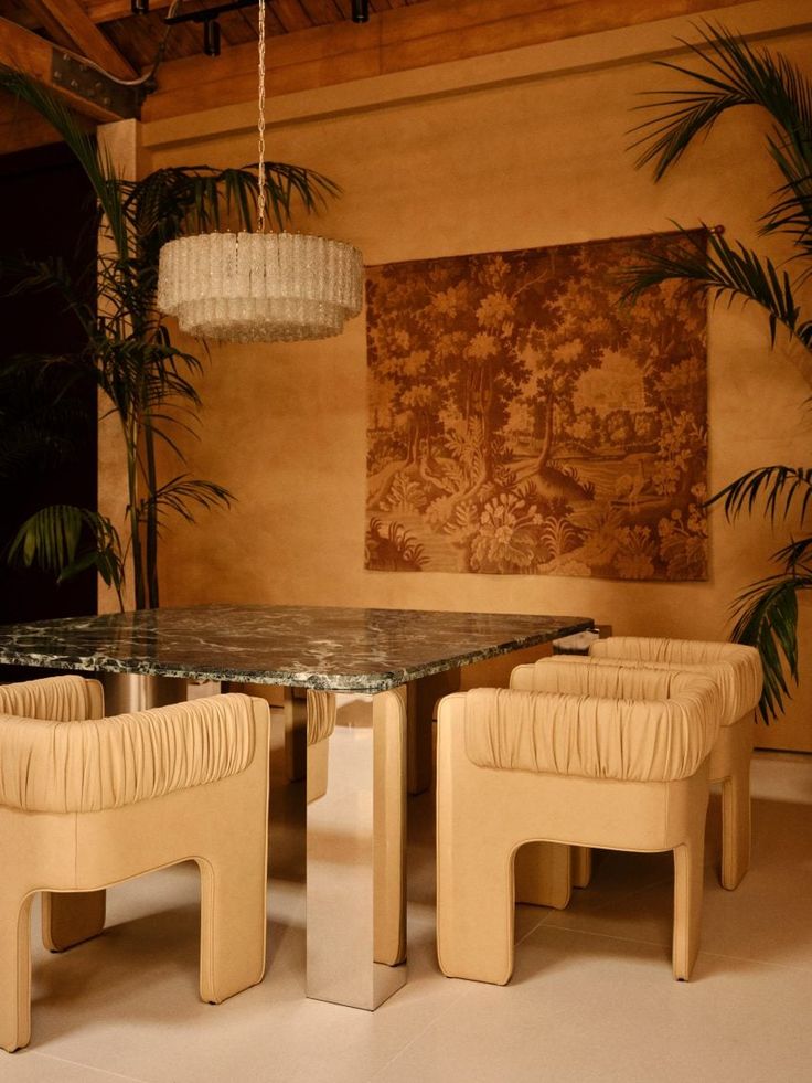 a dining room table with four chairs and a chandelier hanging from the ceiling