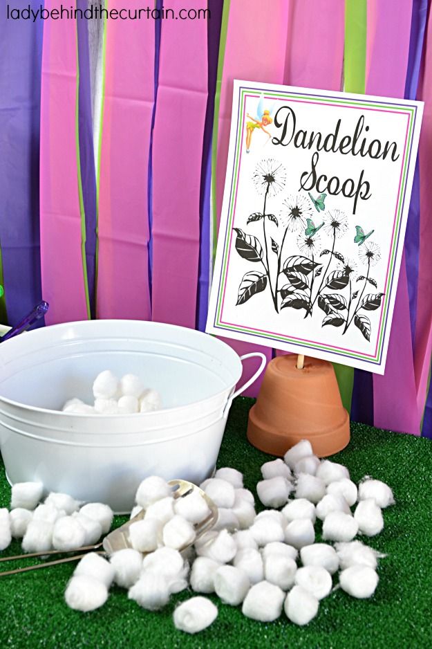 there is a bucket and some cotton balls on the grass next to a sign that says dandelion drop