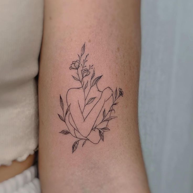 a woman's arm with a flower tattoo on the left side of her arm