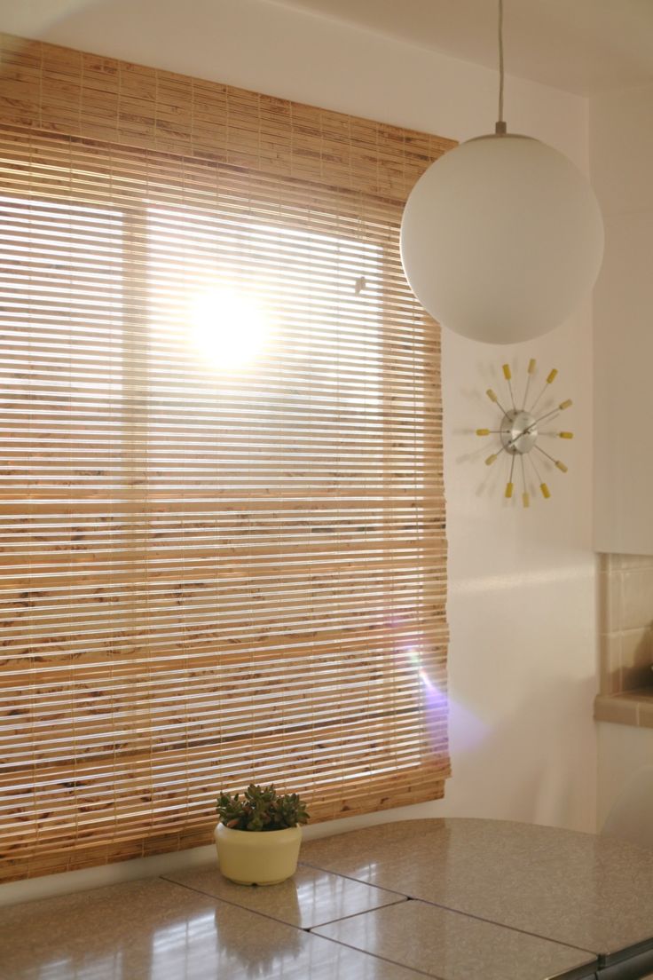 the sun shines through the blinds in this kitchen