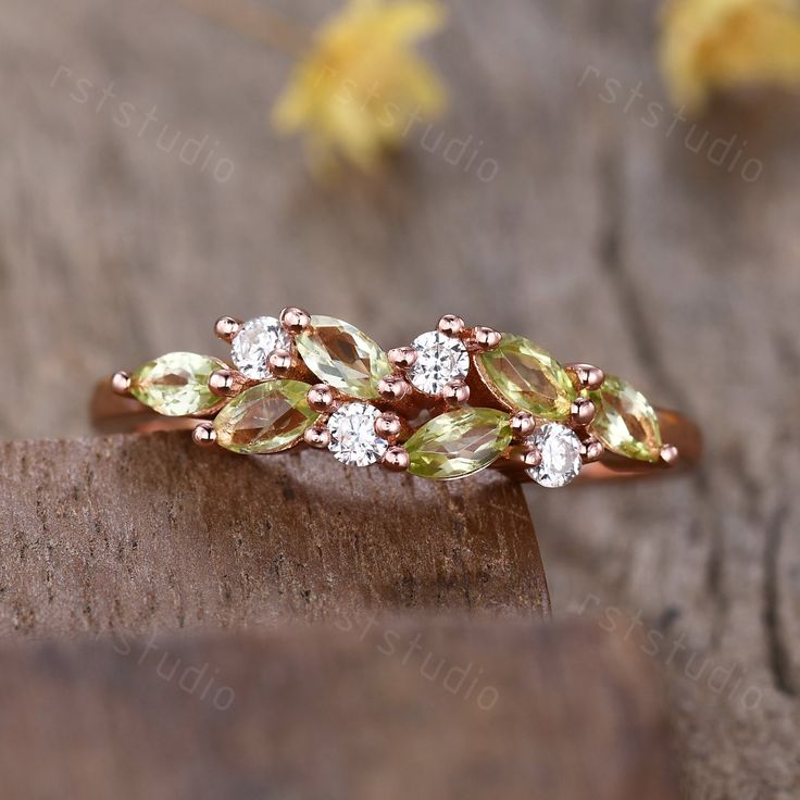 a close up of a ring with green and white stones on it's side