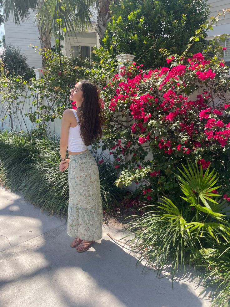 travel, fashion, summer, outfit inspiration, tropical, skirt, floral, flowers, pose, curly hair, white tank top, sandals, beach vibe, aesthetic Flowers Pose, Long Skirt Outfit, Tropical Skirt, Vibe Aesthetic, Long Skirt Outfits, Hair White, Sandals Beach, Skirt Floral, Summer Outfit Inspiration