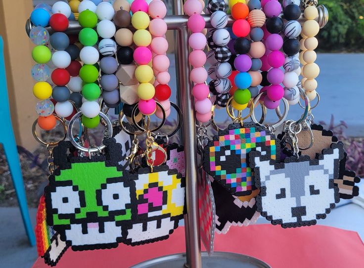 Keychain wristlets with perler designs. each one is handmade and includes a clasp and loop for adding your keys or extra charms. clasp allows for the keychain to be hook to a lanyard or even the belt loop of your pants. When ordering please specify which designs you are interested. If a specific design is not listed then a random one will be sent. Multicolor Keychain With Key Leash As Gift, Fun Handmade Keychains, Wristlet Keychain, Badge Design, Pin Badges, Lanyard, Labour Day, Pet Supplies, Accessory Gift