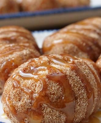 cinnamon buns with icing and sugar on them sitting on a blue and white plate