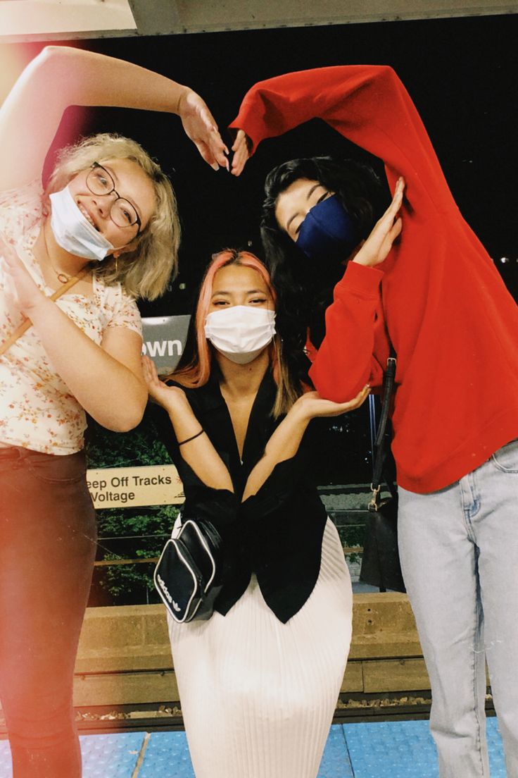 three women with face masks on posing for the camera