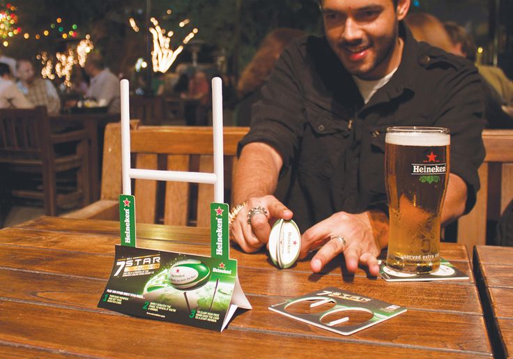 a man sitting at a table with two beer glasses and some papers on the table