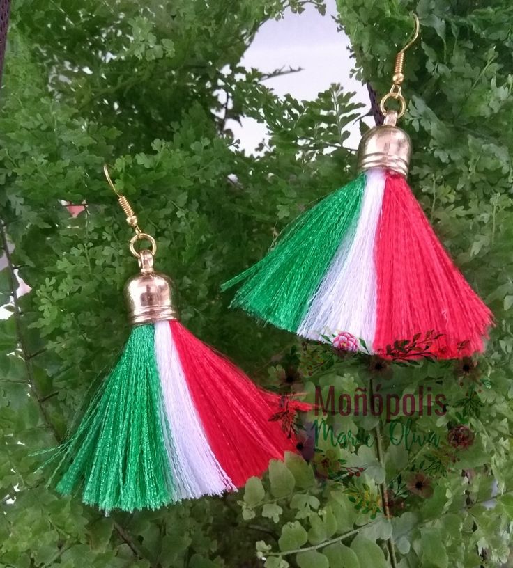 two red, white and green tasselled earrings hanging from gold - plated hooks