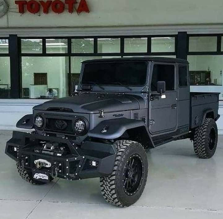 a black jeep parked in front of a toyota dealership