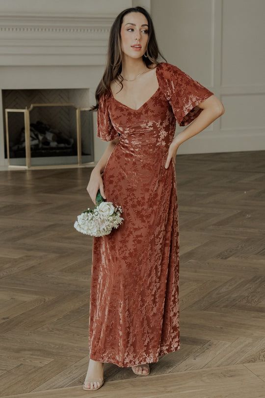 a woman in a long dress holding a bouquet