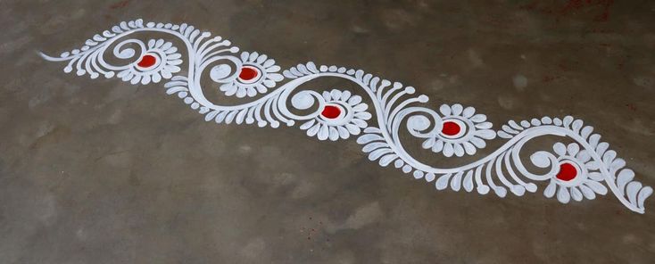 a white and red design on the floor with some red beads in it's center