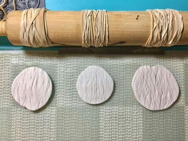 three different types of wood are on the table next to a roll of thread and a pair of scissors