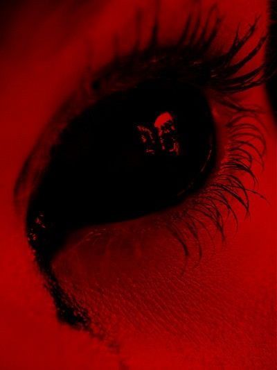 an eye is shown with red light coming from the iris's eyes and black eyelashes