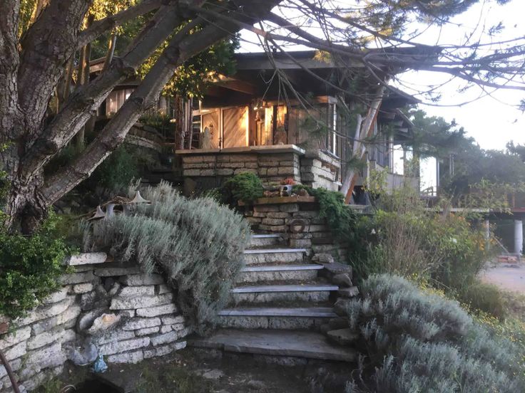 there is a stone wall and steps leading up to the house