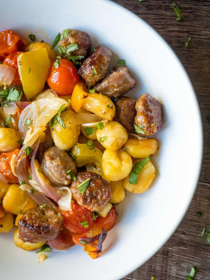 a white bowl filled with lots of different types of food on top of a wooden table