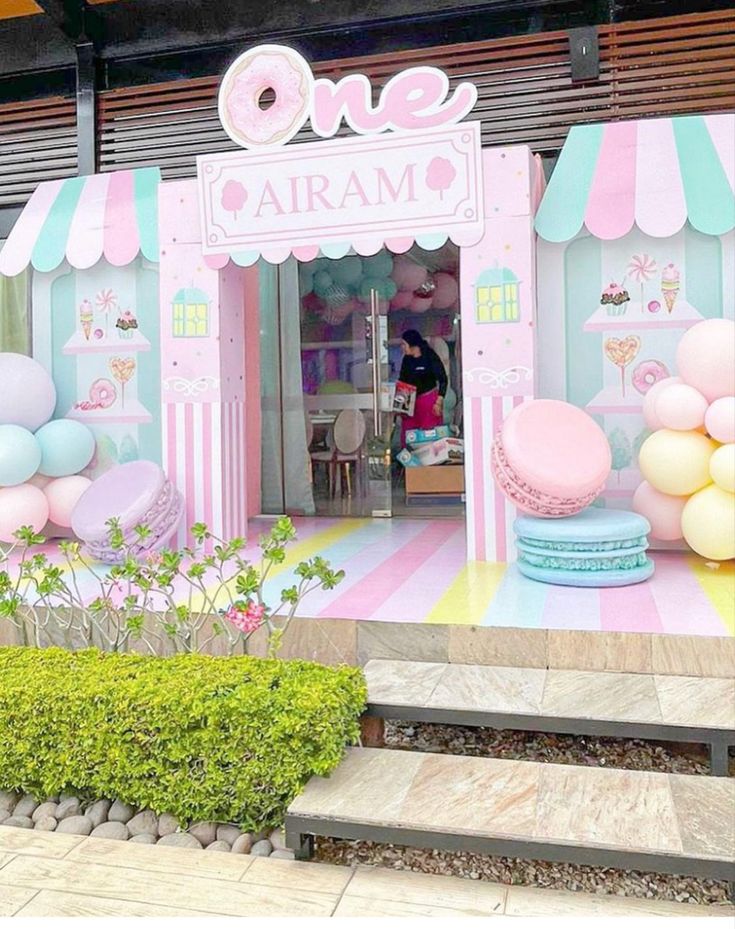 a pink and blue store front with balloons