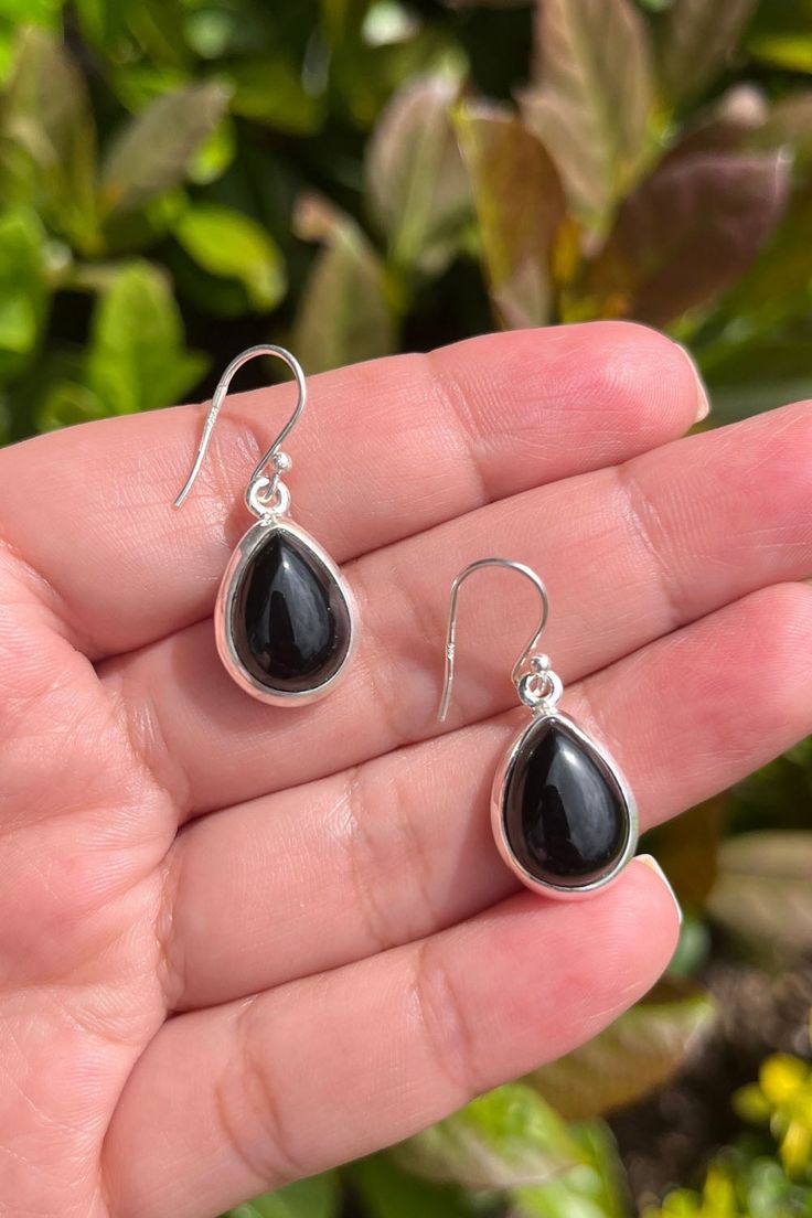 Bliss is an elegant pair of light-weight drop earrings perfect for everyday wear. Featuring high quality natural pear-cut black onyx gemstones, nestled elegantly in a fine sterling silver frame, our Bliss earrings will leave you radiating with inner joy all day long. Authentic Sivalya Black Onyx Black Onyx: Endurance, Perseverance, Grounding Hallmarked Metal: 925 Sterling Silver Gemstone Size: 15mm x 10mm Cut: Pear Cut Smooth Cabochons Silver Onyx Teardrop Earrings, Silver Teardrop Jewelry With Black Enamel, Teardrop Black Enamel Earrings For Gift, Black Enamel Teardrop Earrings For Gift, Elegant Black Sterling Silver Teardrop Earrings, Elegant Black Teardrop Earrings In Sterling Silver, Elegant Black Teardrop Sterling Silver Earrings, Black Sterling Silver Teardrop Earrings, Black Teardrop Sterling Silver Earrings