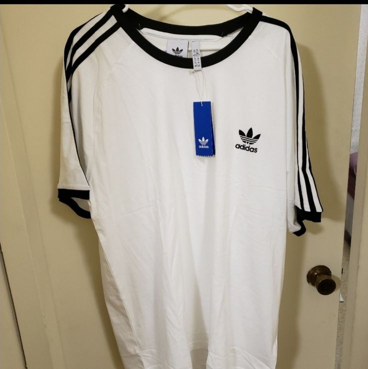 Men's Adidas T-Shirt White Relaxed Fit T-shirt With Three Stripes, Adidas White Sporty T-shirt, White Adidas Sporty T-shirt, White Adidas Crew Neck T-shirt, Sporty White T-shirt With Three Stripes, Adidas Three Stripes T-shirt For Streetwear, Adidas White T-shirt For Streetwear, Basic Adidas T-shirt With Three Stripes, Adidas Basic T-shirt With Three Stripes