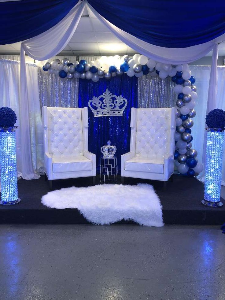 a decorated stage with white chairs and blue balloons