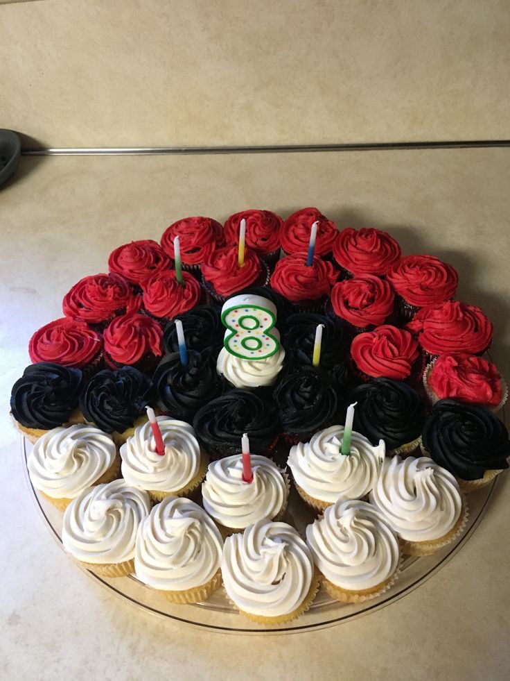 cupcakes with candles are arranged in the shape of a number on a plate