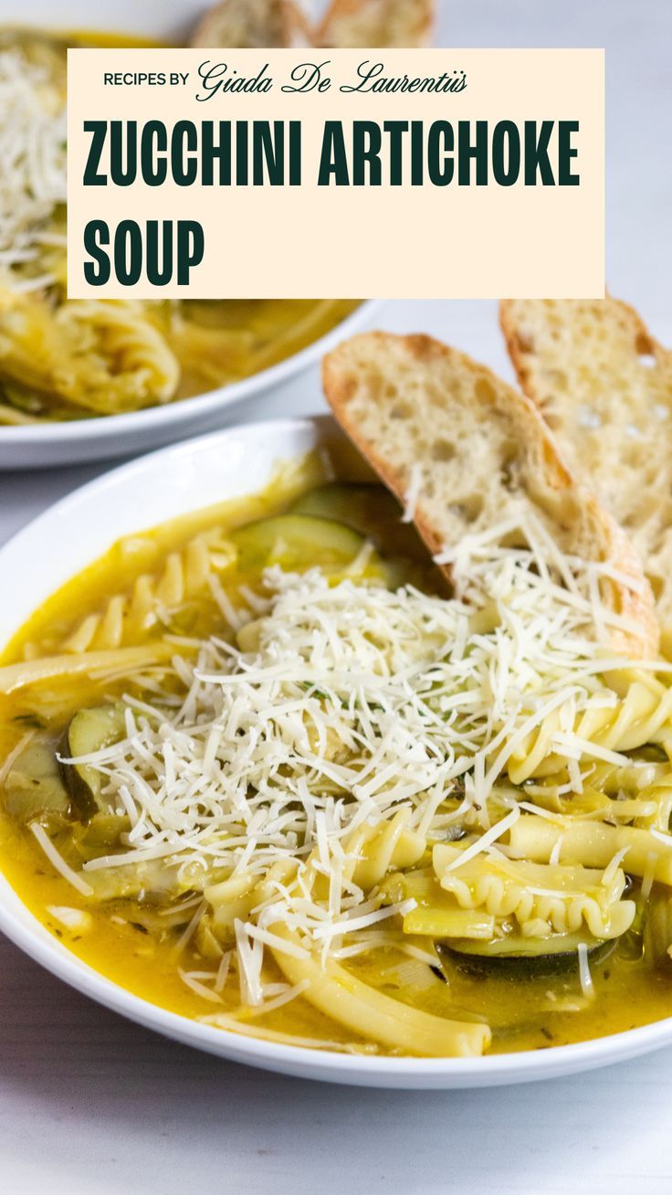 two white bowls filled with zucchini artichoke soup and bread on the side