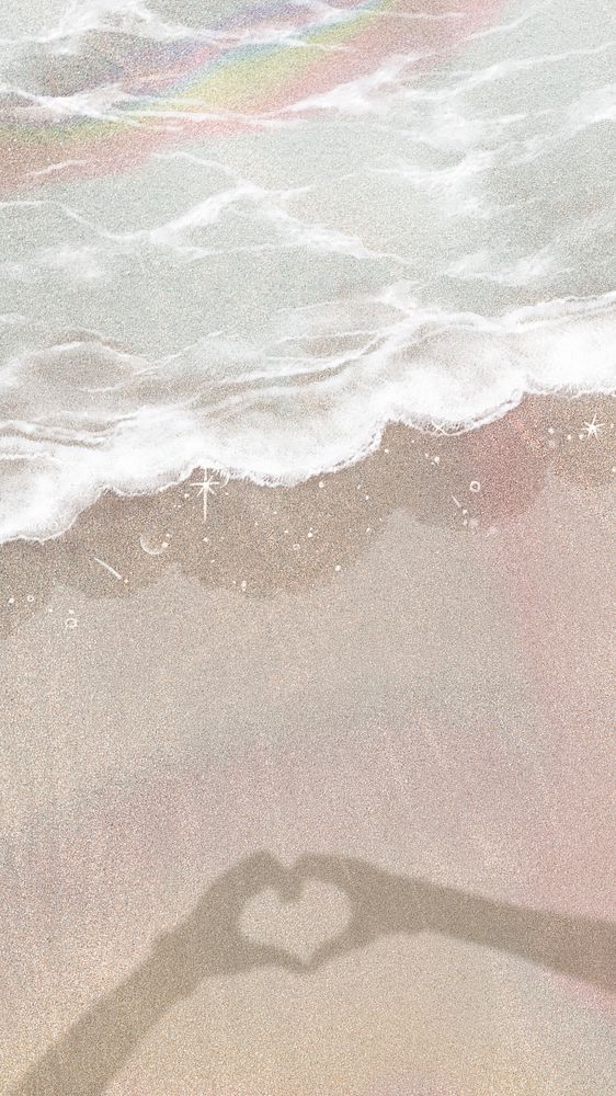 the shadow of a person making a heart shape on the sand near the water's edge