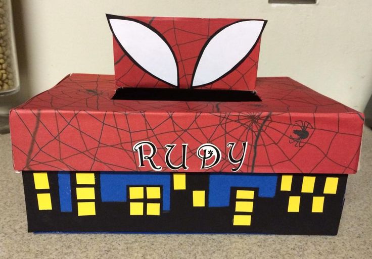 a cardboard box with a spiderman face on the top and words ruby painted on it