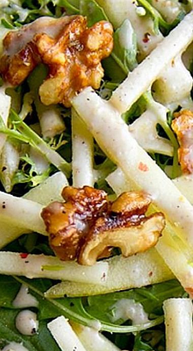 a salad with broccoli, onions and walnuts on it is ready to be eaten