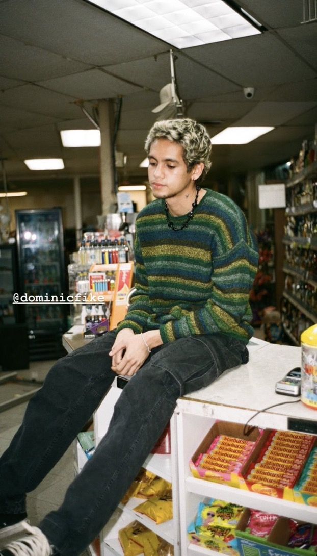 a man sitting on top of a counter in a store