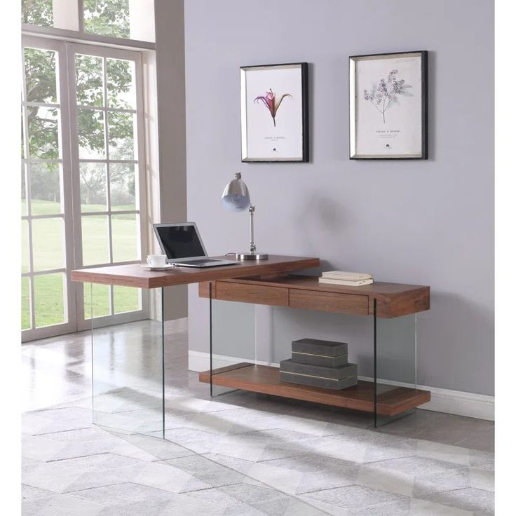 a laptop computer sitting on top of a wooden desk in front of a large window