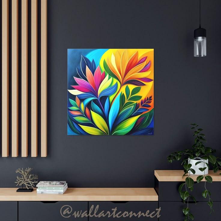 a colorful painting on the wall above a table with a vase and plant next to it