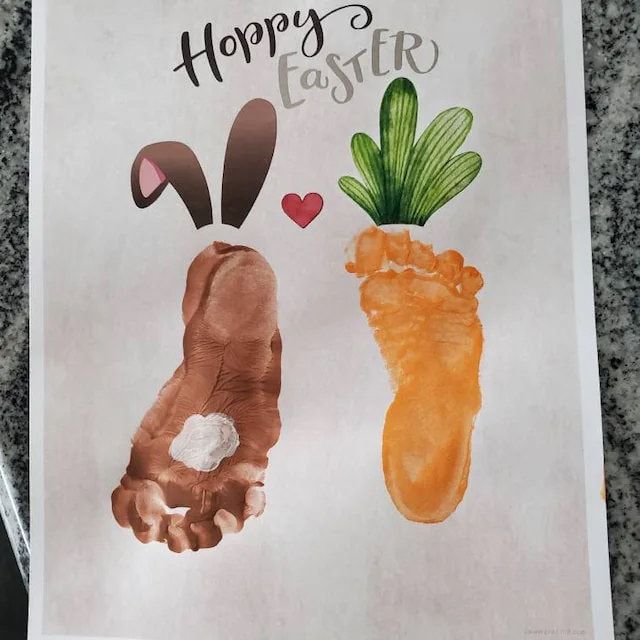 this is a handprint of two carrots and the words happy easter on it