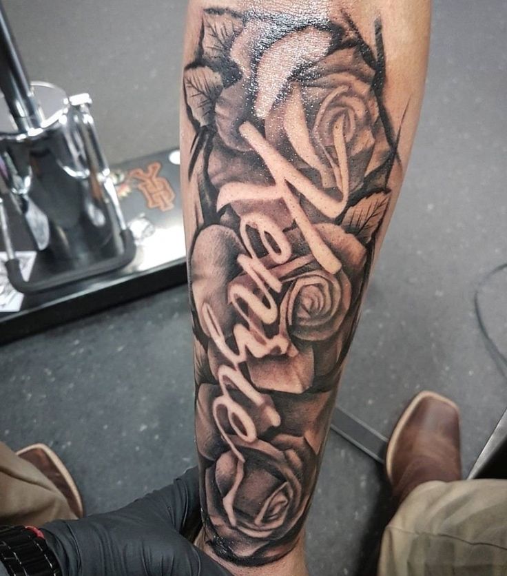 a man's leg with roses and the word love tattooed on it