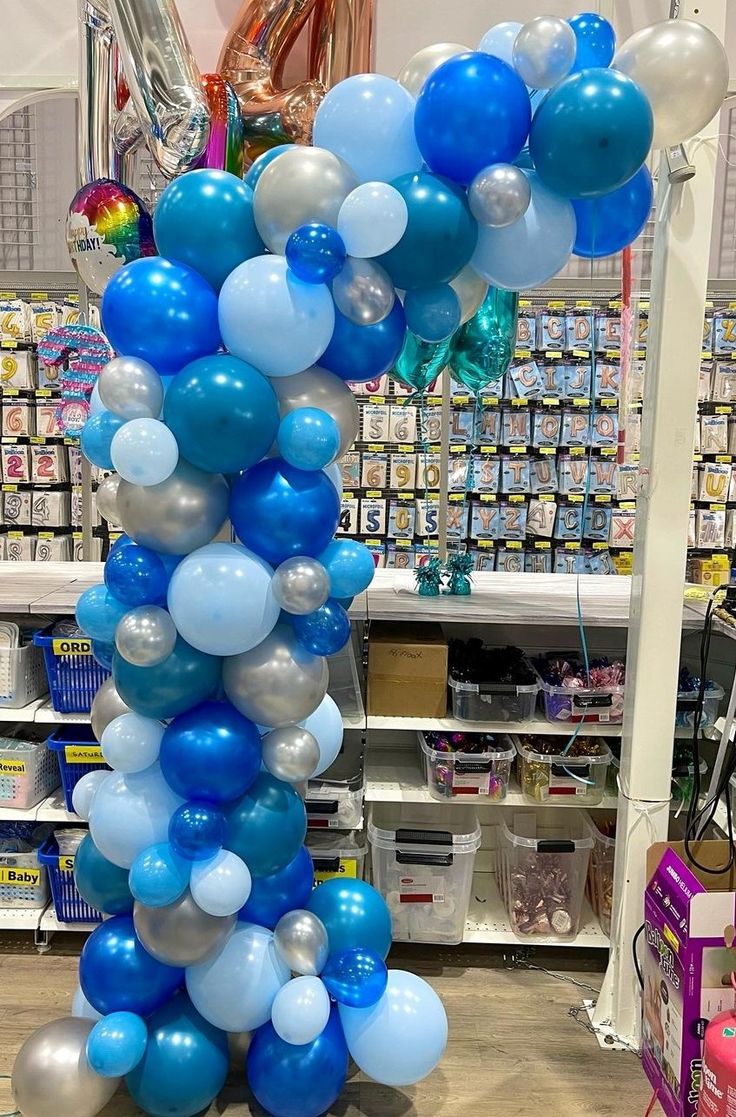 blue and white balloons are stacked on top of each other in the middle of a store