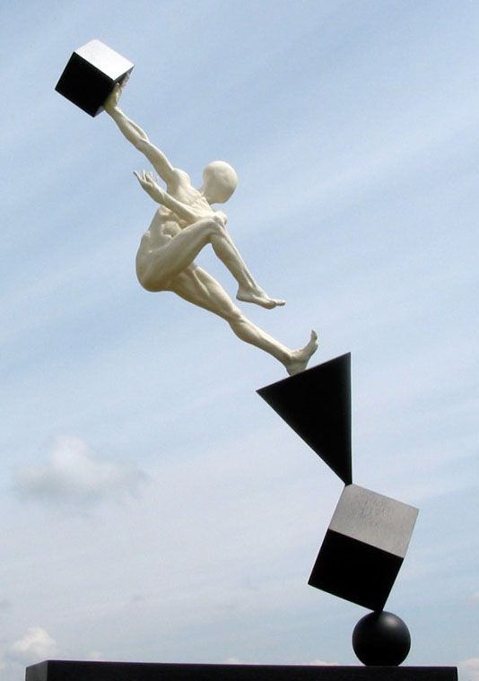 a white statue holding a black and white object in it's right hand while flying through the air