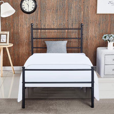 a white bed sitting next to a wooden wall with a clock on it's side