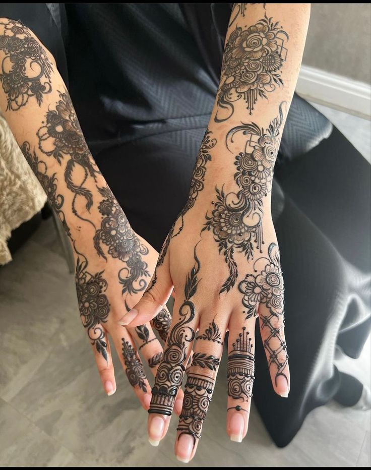 two hands with henna tattoos on them