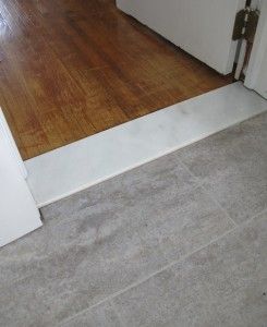 an empty room with hard wood floors and white door handles on the front entrance way