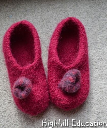 a pair of red slippers sitting on top of a carpet