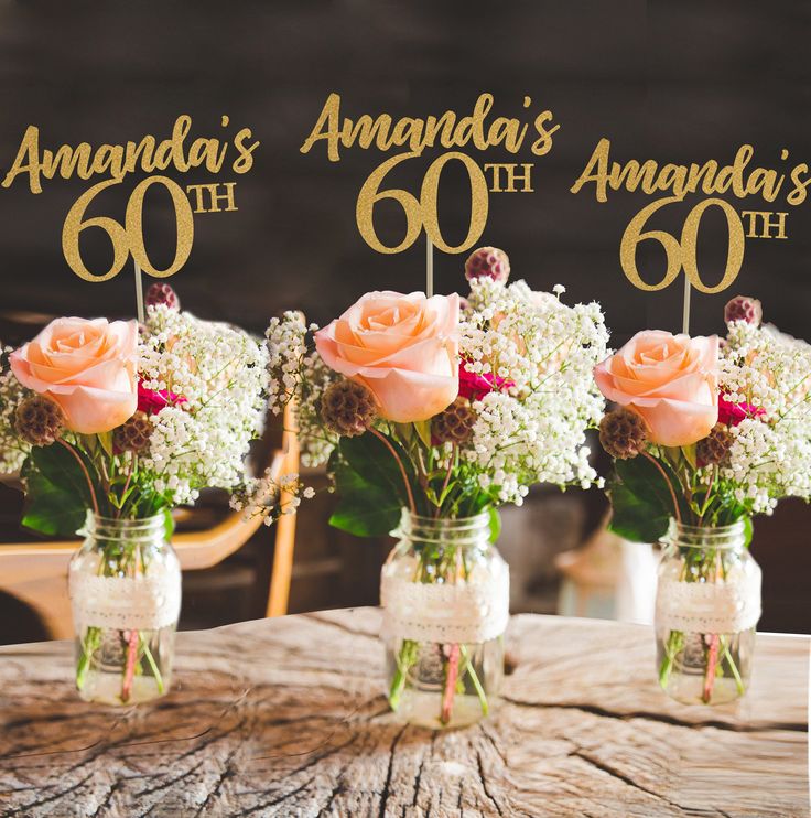 three mason jars filled with flowers sitting on top of a table next to each other